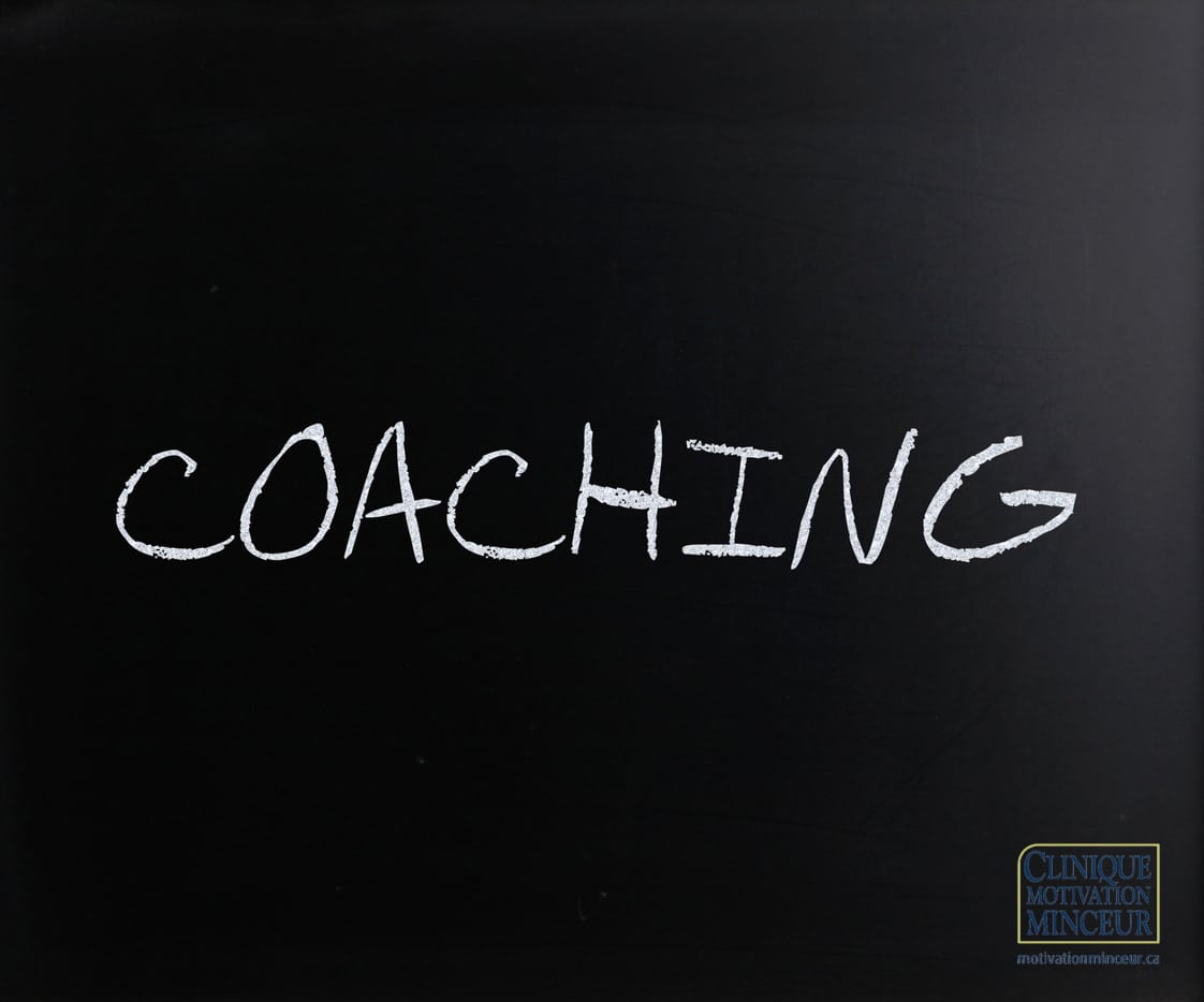 "Coaching" handwritten with white chalk on a blackboard